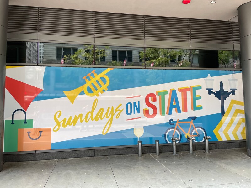 Chamber Municipality Sundays on State Bannerville Window Treatment graphics storefront graphics retail signage event signs chicago loop alliance Illinois 